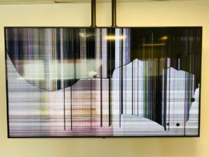 A picture of a broken TV with a cracked LCD panel screen,